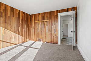 Spare room with carpet flooring and wood walls
