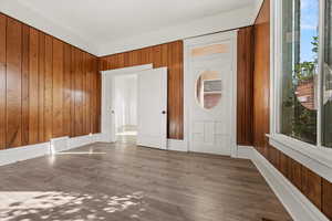 Unfurnished room featuring wooden walls and wood finished floors