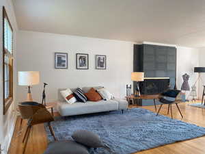 Living area featuring crown molding, wood finished floors, and a tiled fireplace