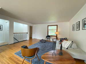 Living room featuring wood finished floors, crown molding, and a textured ceiling