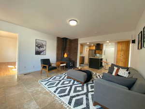 Living area with a wood stove, light tile patterned floors, and recessed lighting