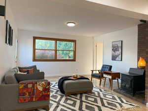 Living room featuring a wood stove and baseboards