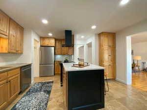 Kitchen featuring a center island, stainless steel appliances, recessed lighting, a kitchen bar, and light stone counters