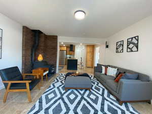 Living room featuring light tile patterned floors and a wood stove