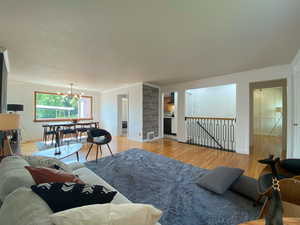 Living area with a chandelier, light wood-type flooring, and crown molding