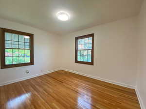 Unfurnished room with hardwood / wood-style flooring and baseboards