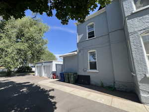 View of property exterior featuring brick siding and an outbuilding