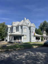 View of front of house with covered porch and a chimney