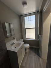 Bathroom with vanity, dark wood-style floors, and a wainscoted wall