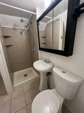 Full bathroom with tile patterned floors and a stall shower