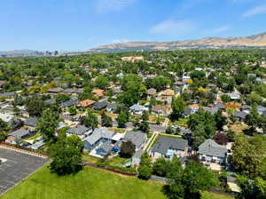 Aerial view of property and surrounding area with a mountainous background and nearby suburban area