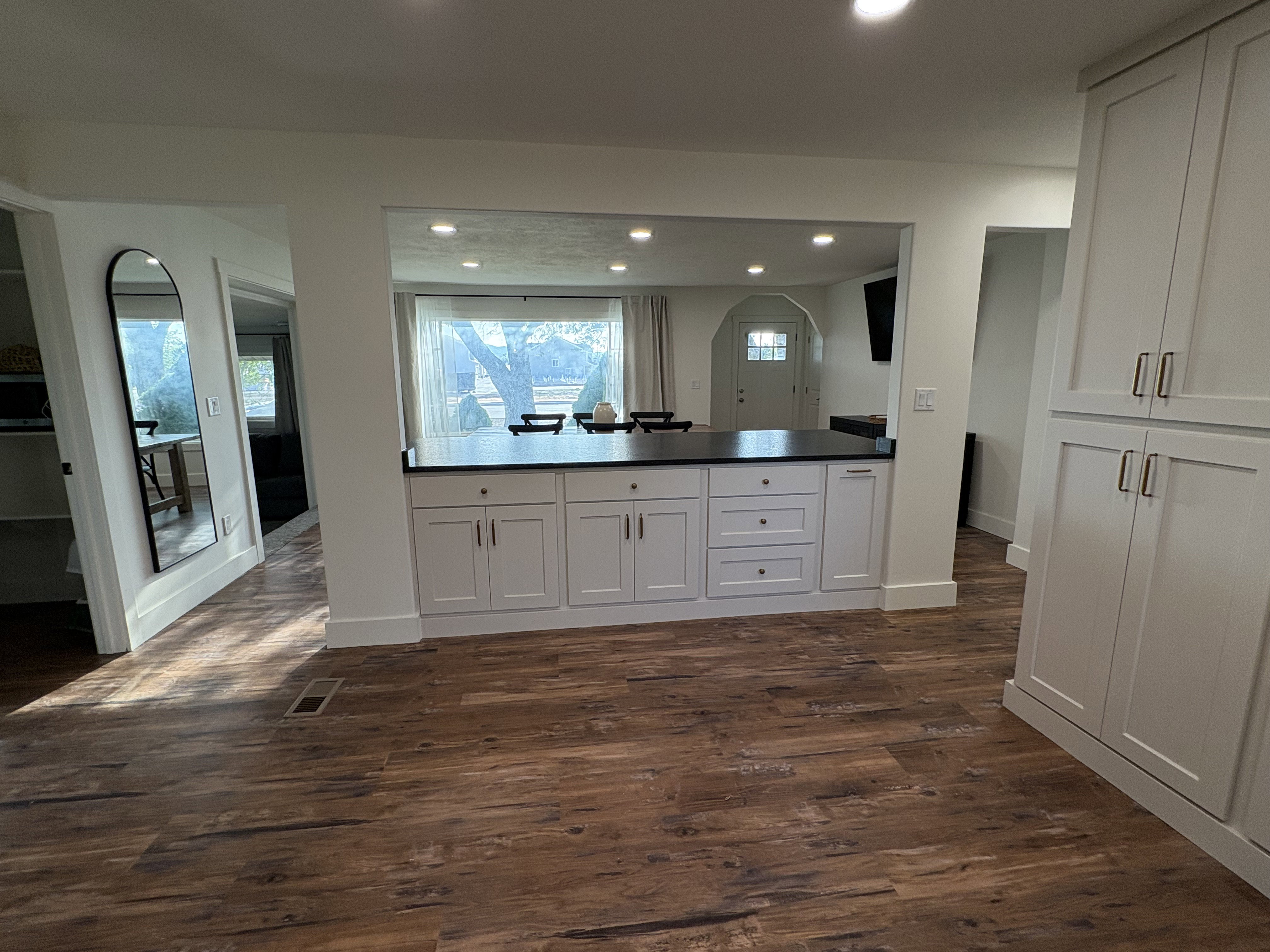 Kitchen with white cabinetry, healthy amount of natural light, dark wood finished floors, recessed lighting, and a peninsula