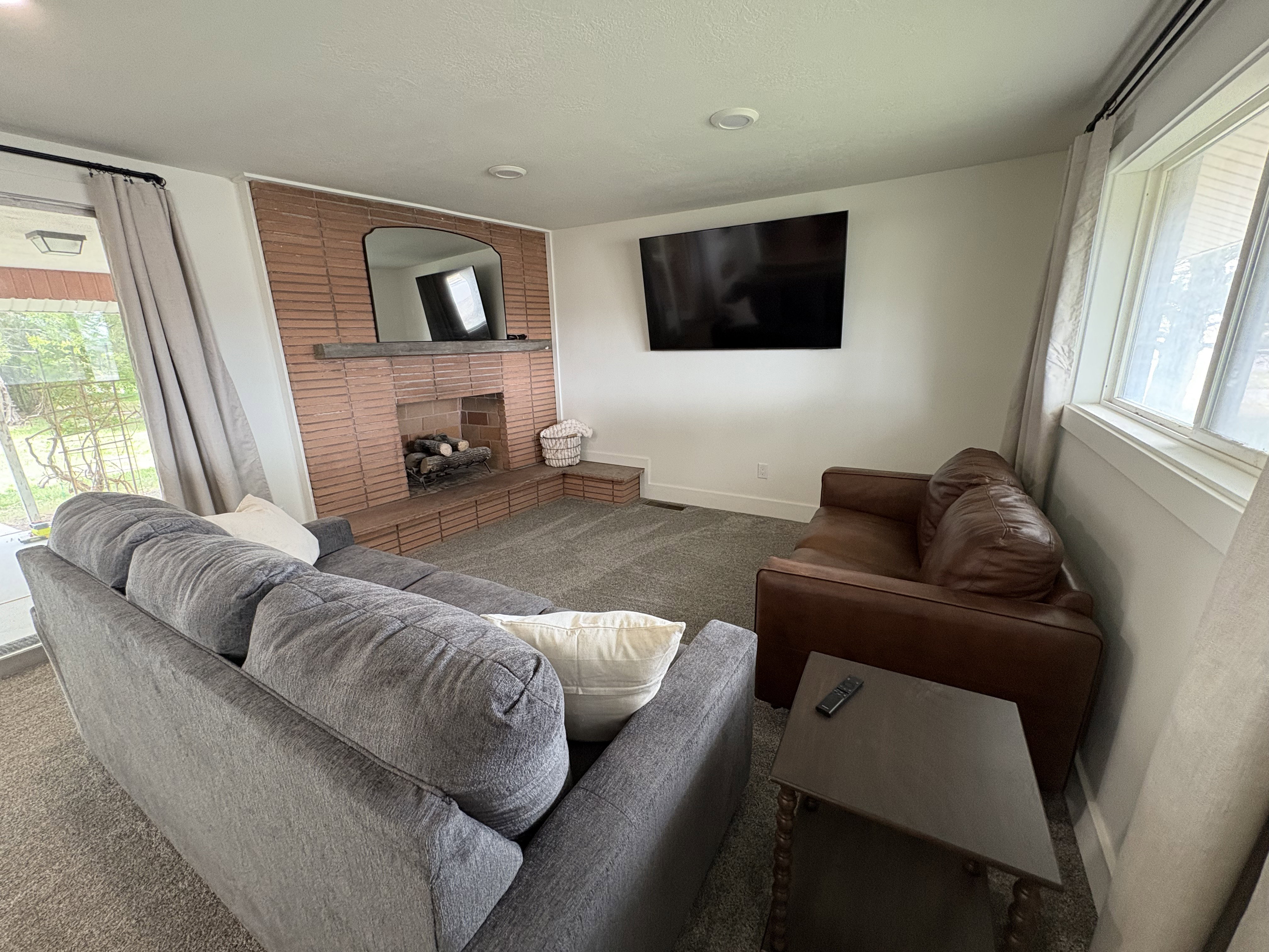 Living room with healthy amount of natural light, a brick fireplace, and carpet flooring