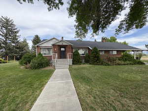 Ranch-style house with brick siding, a front yard, and a chimney