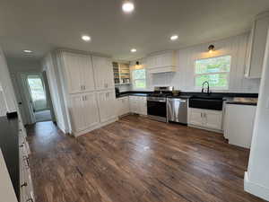 Kitchen featuring dark countertops, open shelves, white cabinets, stainless steel appliances, and healthy amount of natural light