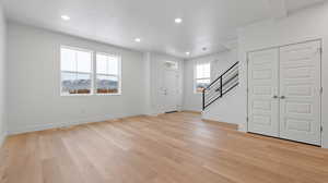 Entryway with recessed lighting, stairs, and light wood finished floors