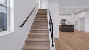 Stairs featuring wood finished floors and recessed lighting