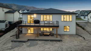 Rear view of property with stairway, roof with shingles, stucco siding, and a deck with mountain view