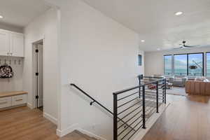 Stairway with recessed lighting, wood finished floors, and ceiling fan