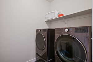 Laundry area with baseboards and washer and dryer