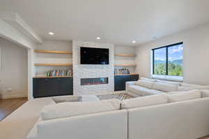 Living room featuring a fireplace, light wood-style flooring, and recessed lighting