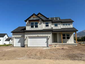 View of front of property with roof with shingles, a porch, an attached garage, board and batten siding, and dirt driveway