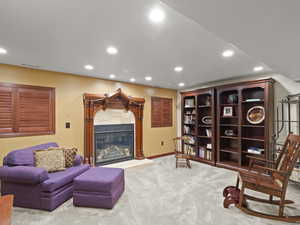 Living area with recessed lighting, light carpet, and a gas fireplace