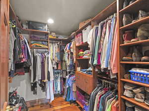 Spacious closet with wood finished floors in main bedroom