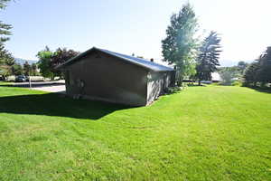 View of side of home with a lawn and brick siding