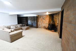 Carpeted living room with a wood stove and heating unit