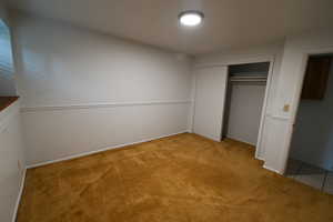 Unfurnished bedroom featuring light colored carpet and a closet