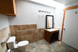 Half bath with vanity and tile walls