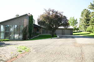 View of front of house featuring asphalt driveway, a front yard, and a chimney