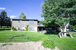 Rear view of house featuring a yard and a patio
