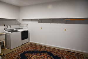 Washroom with baseboards and washing machine and dryer