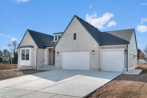 View of front of property with brick siding, driveway, a shingled roof, and a garage