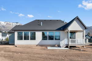 Back of house with roof with shingles and a deck with mountain view