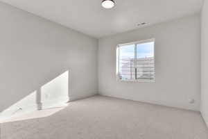 Carpeted spare room featuring baseboards