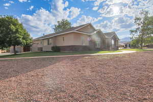 View of front of house with brick siding, stucco siding, and a front yard
