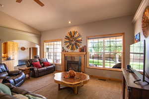 Living room with lofted ceiling, healthy amount of natural light, carpet flooring, recessed lighting, and a fireplace