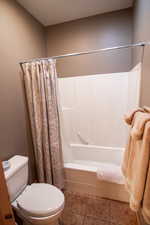 Full bathroom featuring shower / bathtub combination with curtain and tile patterned floors