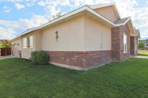 View of home's exterior with a lawn, stucco siding, and brick siding