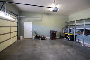 Garage featuring a garage door opener and baseboards