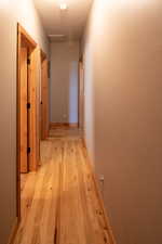 Hallway featuring light wood-style flooring and baseboards