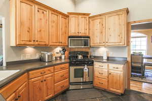 Kitchen with appliances with stainless steel finishes and dark countertops