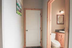 Half bathroom featuring vanity and toilet