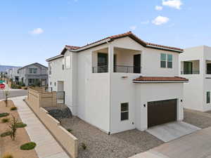 Mediterranean / spanish home featuring a balcony, stucco siding, an attached garage, a tile roof, and driveway