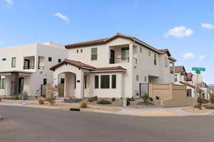 Mediterranean / spanish-style house with a balcony, stucco siding, a tiled roof, and a residential view