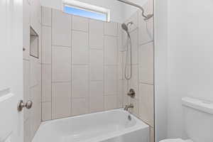 Bathroom featuring washtub / shower combination and toilet