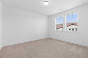 Unfurnished room with light colored carpet